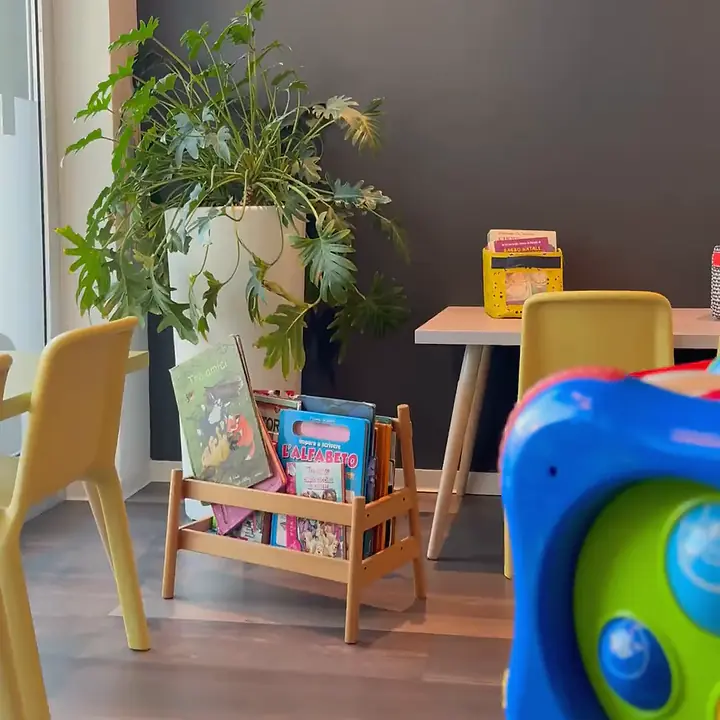 L'angolo dei bambini in sala d'attesa: tavolino, sedie gialle, libri e giochi
