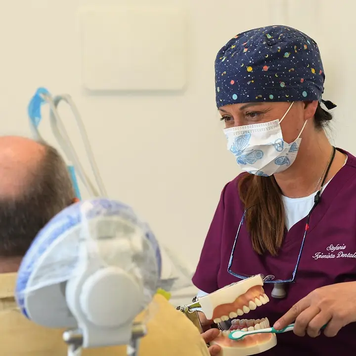 Un'igienista mostra il modello dei denti