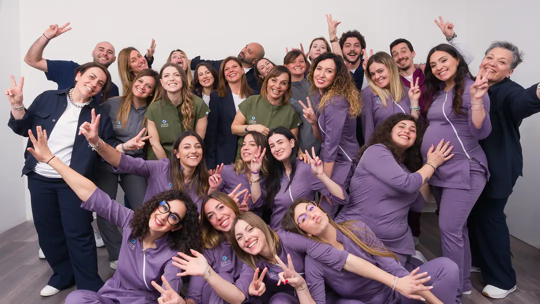 La squadra dello Studio Dentistico Conte nella sala bianca dello studio, sorridente